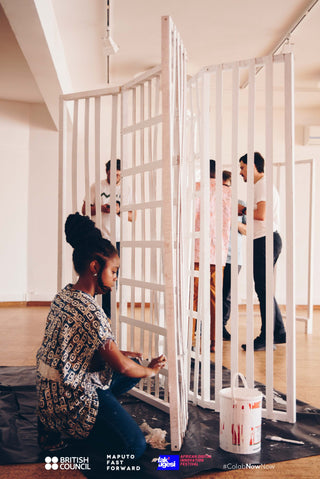 People behind slatted walls, one wearing a headphones